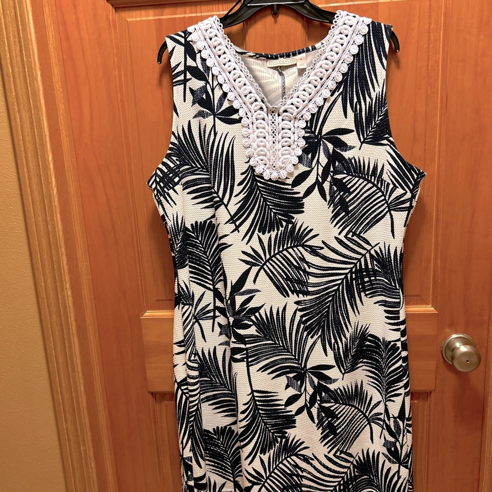 Women’s knee length black and white dress. Has v neck with embroidery design.